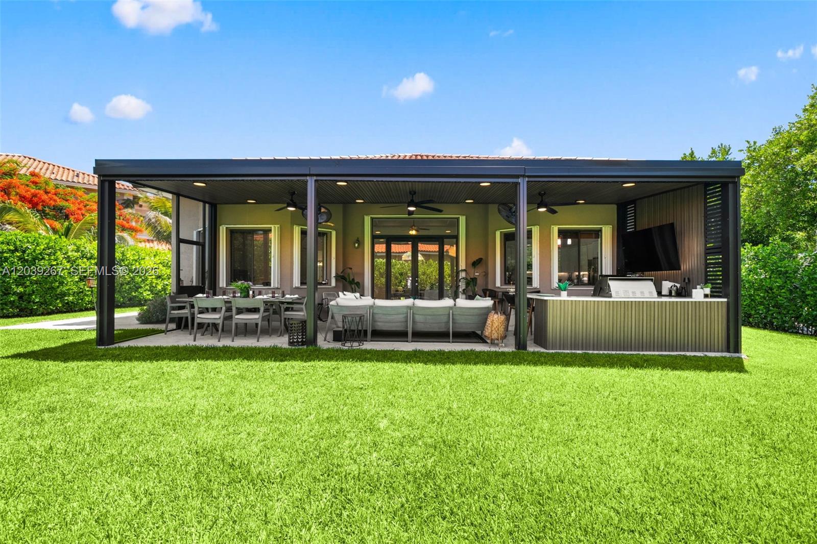 A covered outdoor patio features a dining area, lounge seating, and a built-in kitchen — 7563 SW 188th Ter, Cutler Bay FL 33157, CUTLER BAY, FL