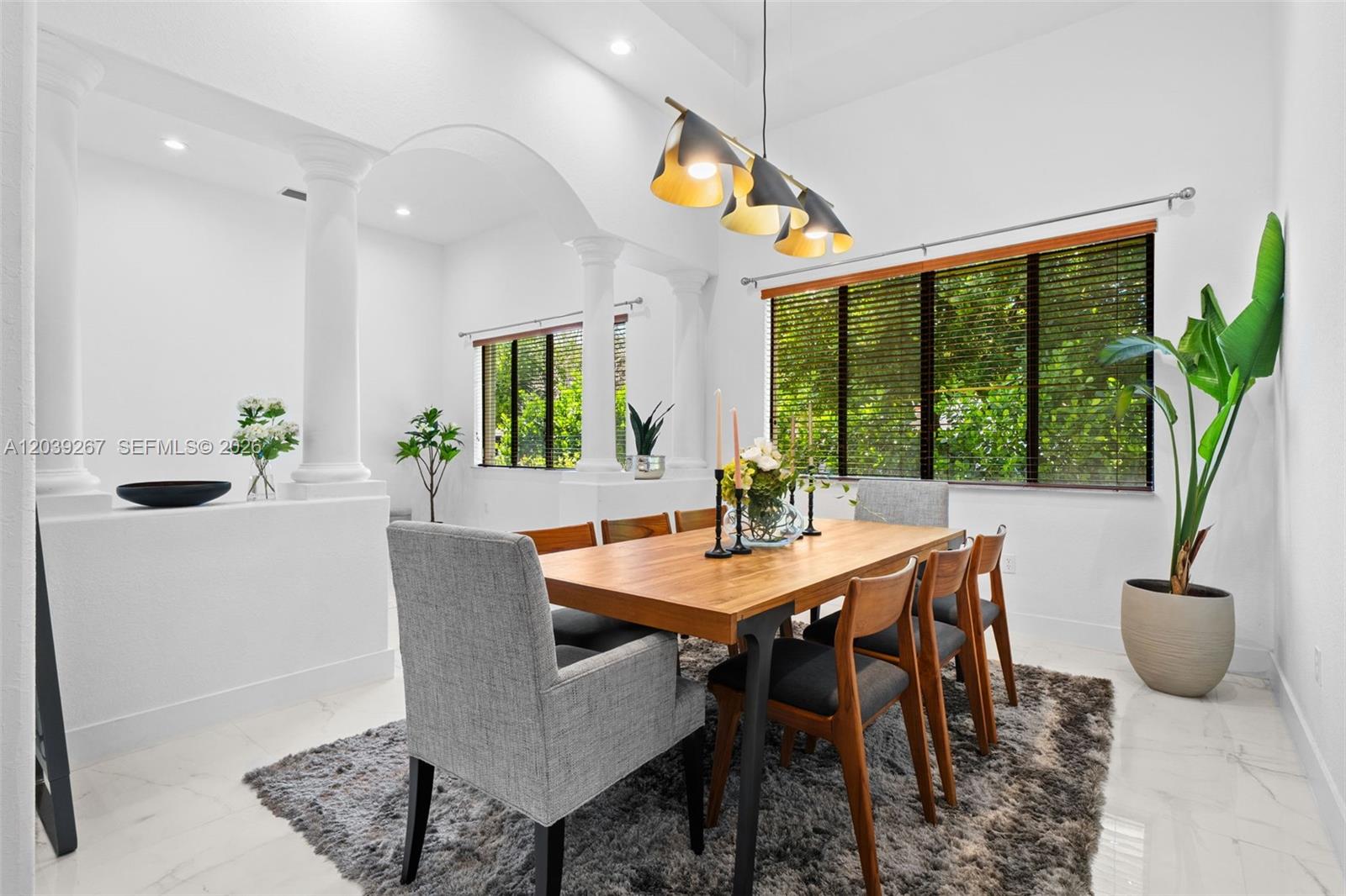 A dining room features a wooden table, gray chairs, a rug, and arched columns — 7563 SW 188th Ter, Cutler Bay FL 33157, CUTLER BAY, FL
