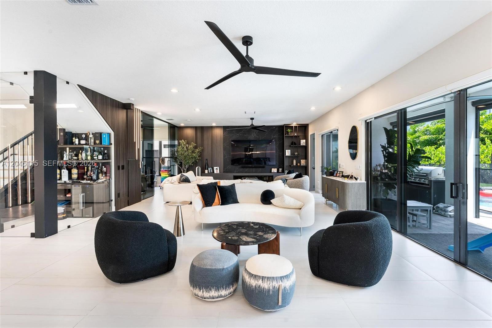 A modern living room features white sofas, black armchairs, a marble coffee table, and a bar — 8524 Shoreacres St, Boca Raton FL 33434, BOCA RATON, FL