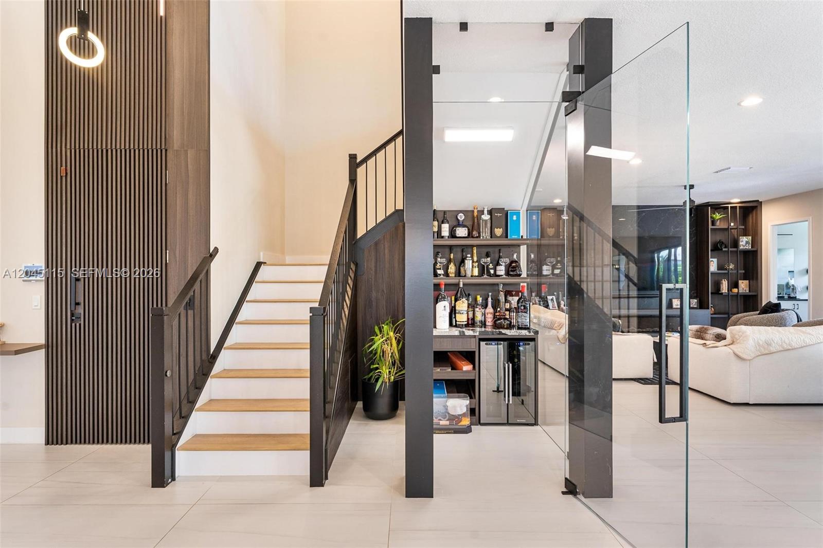 A modern staircase with wooden treads sits beside a glass-enclosed bar area — 8524 Shoreacres St, Boca Raton FL 33434, BOCA RATON, FL