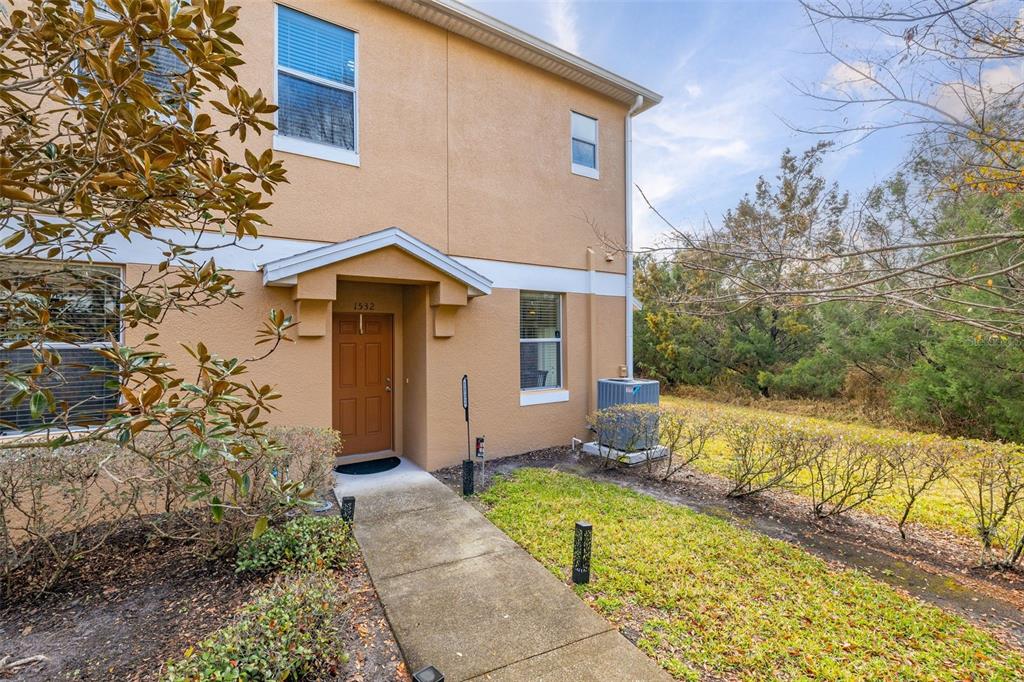 A tan two-story townhouse exterior features a brown front door and a concrete walkway — 1532 SCARLET OAK LOOP UNIT 70B, WINTER GARDEN, FL