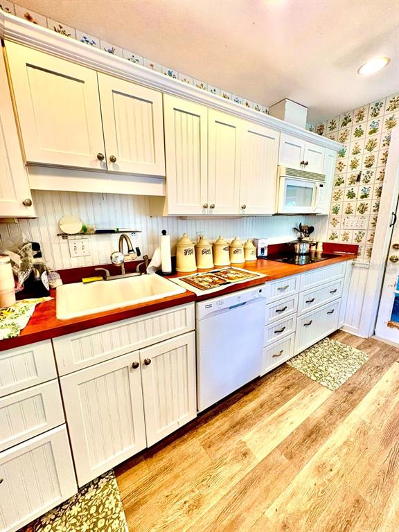 A kitchen features white beadboard cabinets, a wood countertop, and floral-patterned wall tiles — 16 52ND STREET, YANKEETOWN, FL