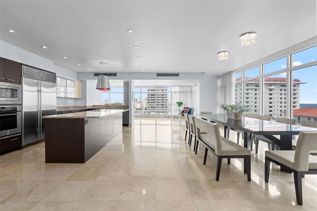 A modern kitchen and dining area with tile floors, stainless steel appliances, and large windows — 1052 ASHFORD AVENUE UNIT 9C, SAN JUAN, PR