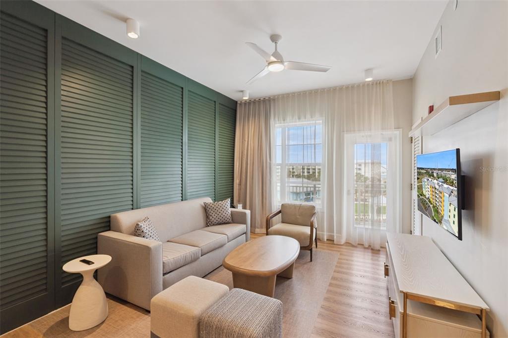 A living room features a green louvered accent wall, a sofa, and a ceiling fan — 8061 VACATION AVENUE UNIT 2508, KISSIMMEE, FL