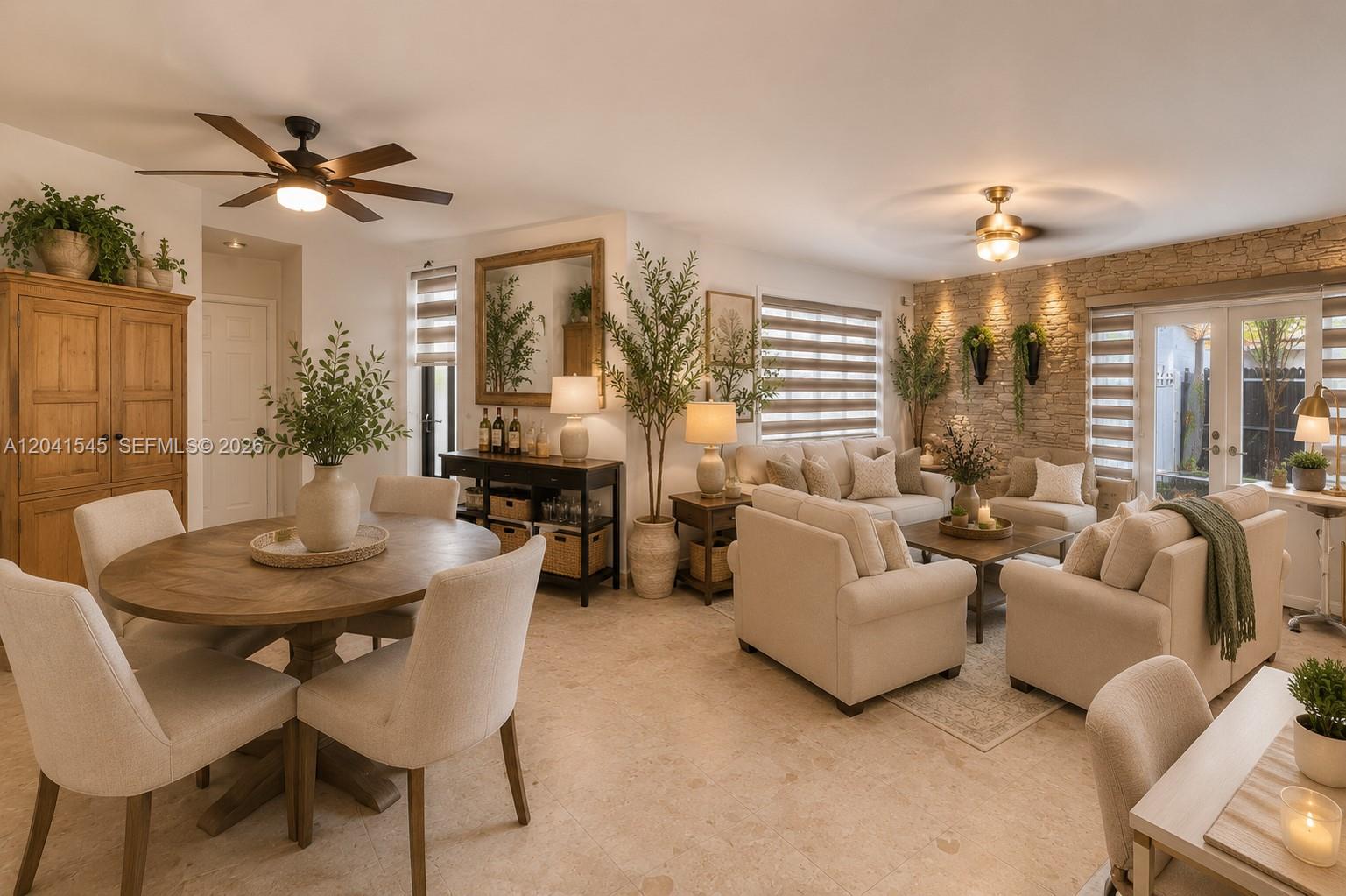 This open-concept living and dining area features stone accent walls, neutral furniture, and tile flooring — 18670 Belview Dr, Cutler Bay FL 33157, CUTLER BAY, FL