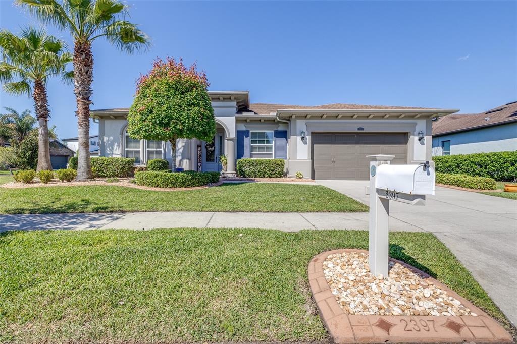 The exterior of a house features a light blue front door, columns, and a garage — 2397 GWYNHURST BOULEVARD, WESLEY CHAPEL, FL