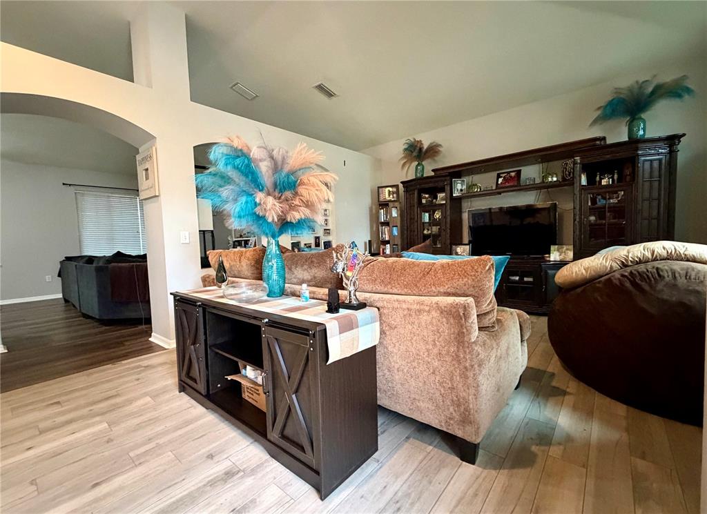 A living room features a brown sofa, a console table, and a large entertainment center — 4303 ORANGE RIDGE COURT, VALRICO, FL
