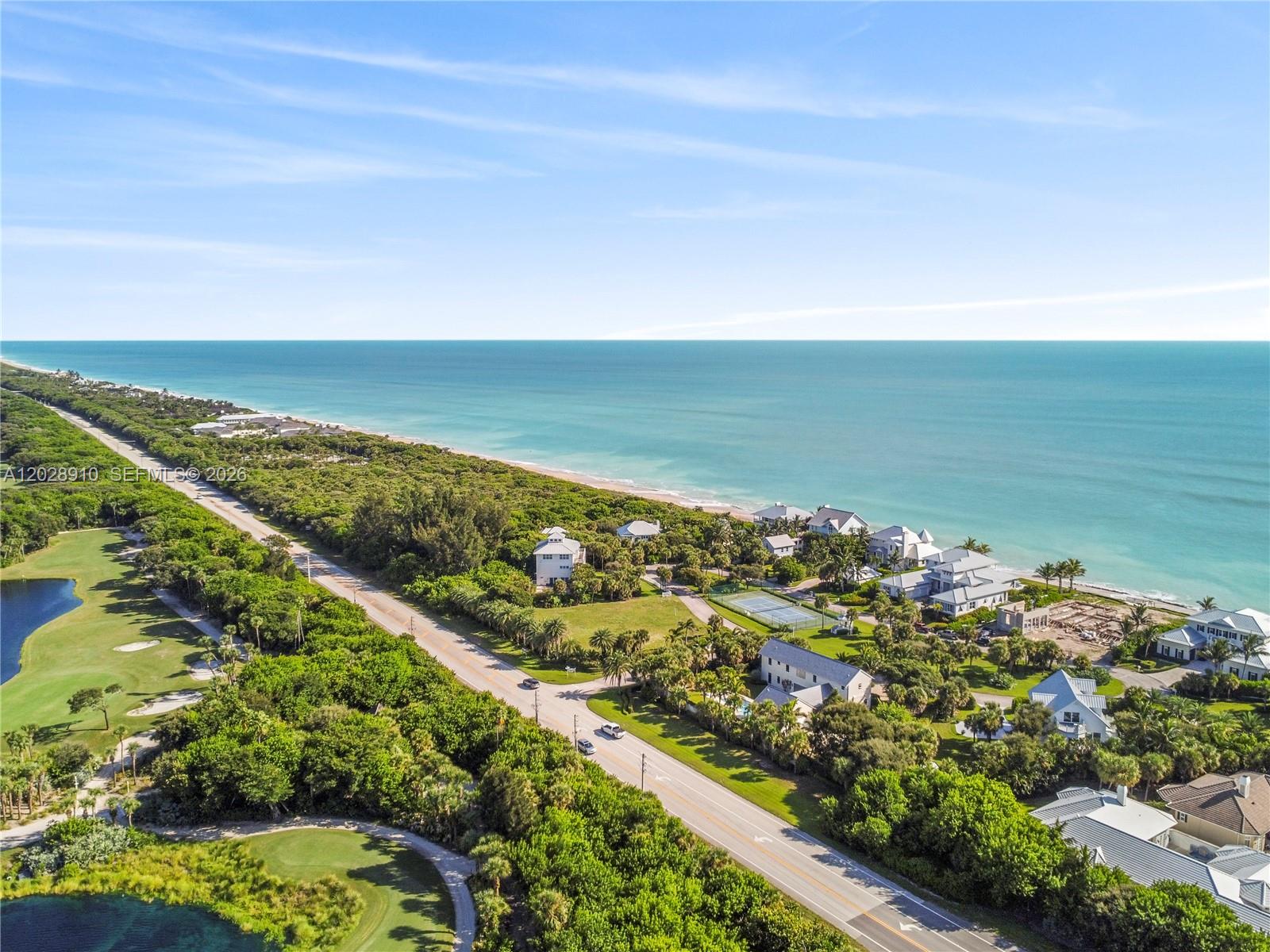An aerial view shows a coastal road separating a golf course from beachfront residential homes — 2335 Sanderling Ln, Vero Beach FL 32963, VERO BEACH, FL