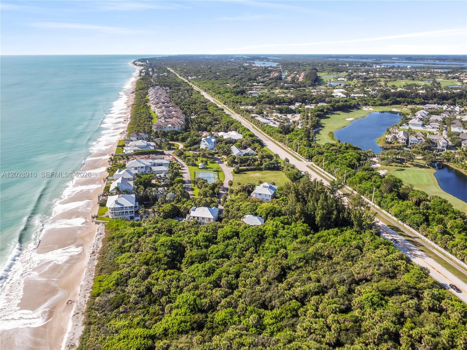 An aerial view shows a coastal neighborhood with houses nestled between the ocean and woods — 2335 Sanderling Ln, Vero Beach FL 32963, VERO BEACH, FL