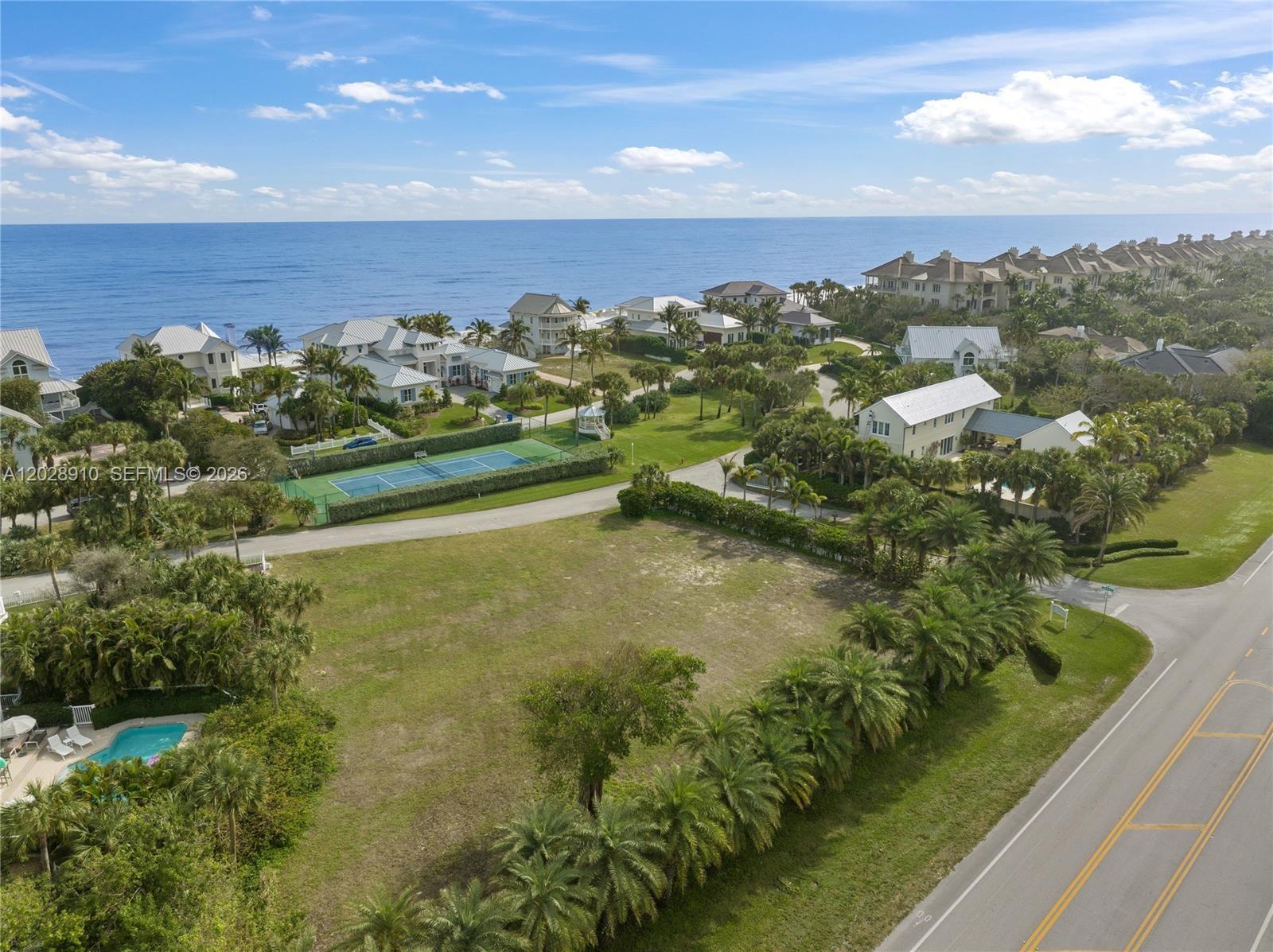 An aerial view shows a vacant lot bordered by palm trees, a road, and oceanfront homes — 2335 Sanderling Ln, Vero Beach FL 32963, VERO BEACH, FL