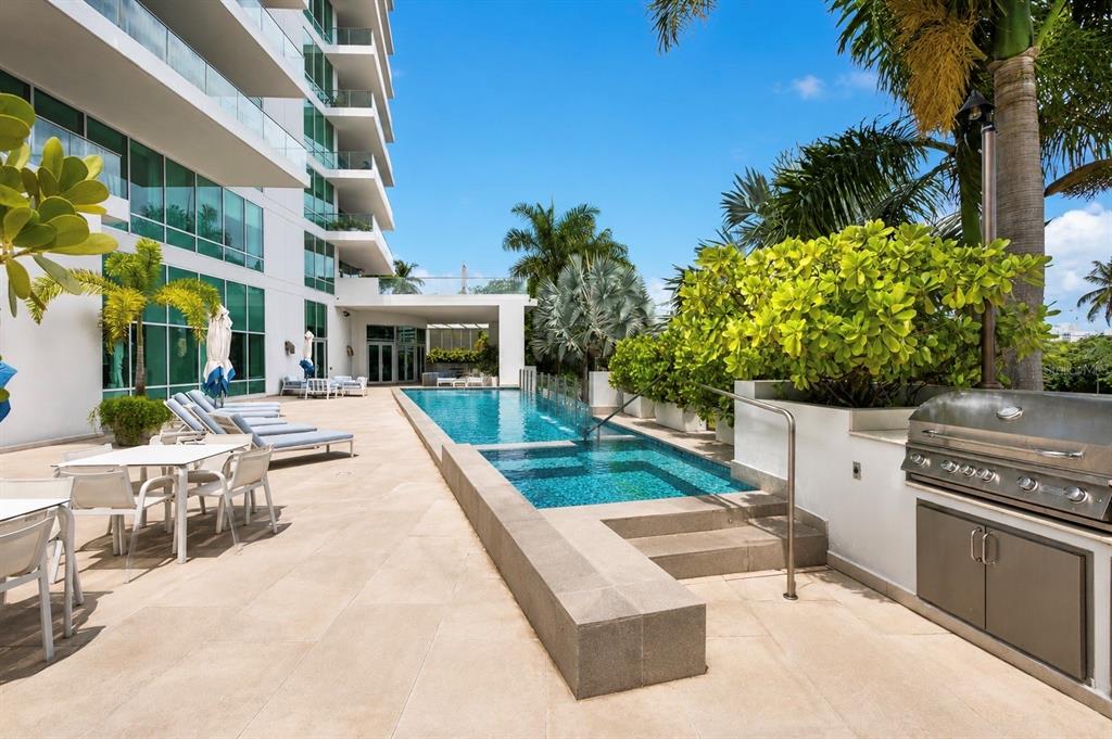A modern outdoor pool deck features a lap pool, lounge chairs, and a stainless steel grill — 555 MONSERRATE, SAN JUAN, PR