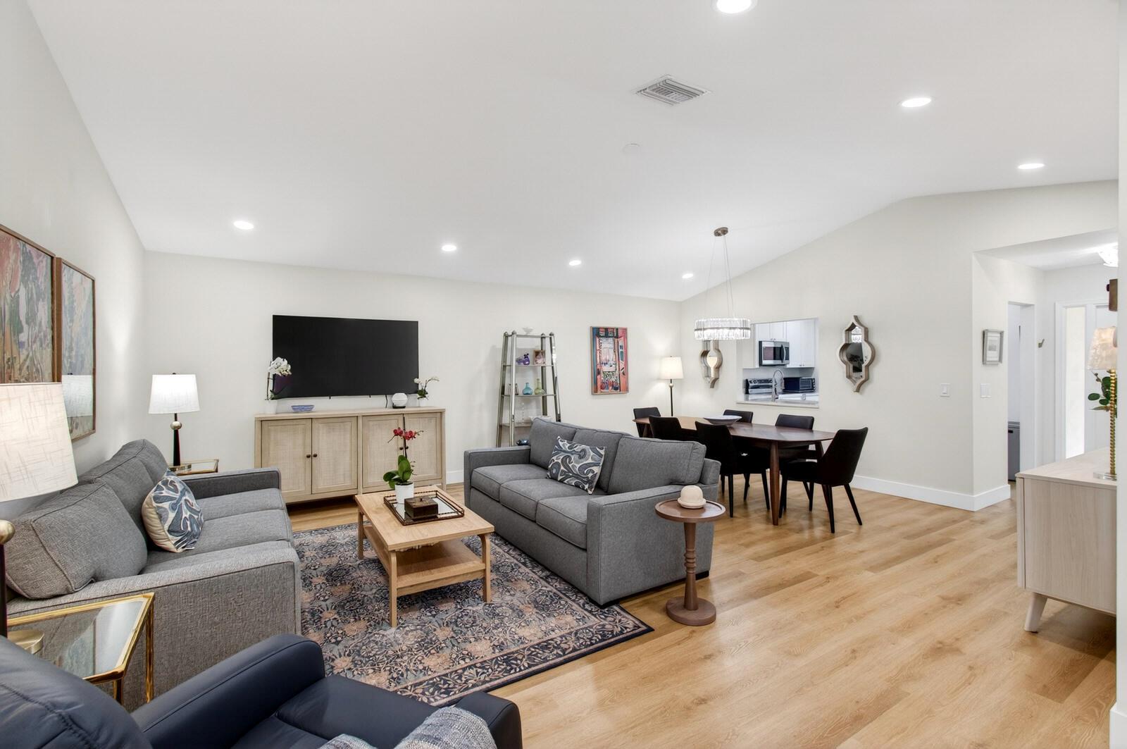 A living and dining room with gray sofas, a wood coffee table, and hardwood floors — 23377 Barlake Drive, Boca Raton FL 33433, BOCA RATON, FL