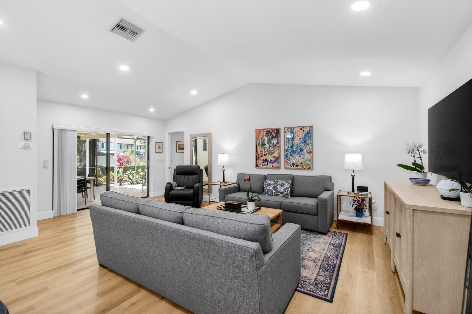 A living room with gray sofas, a wood coffee table, and a sliding glass door — 23377 Barlake Drive, Boca Raton FL 33433, BOCA RATON, FL