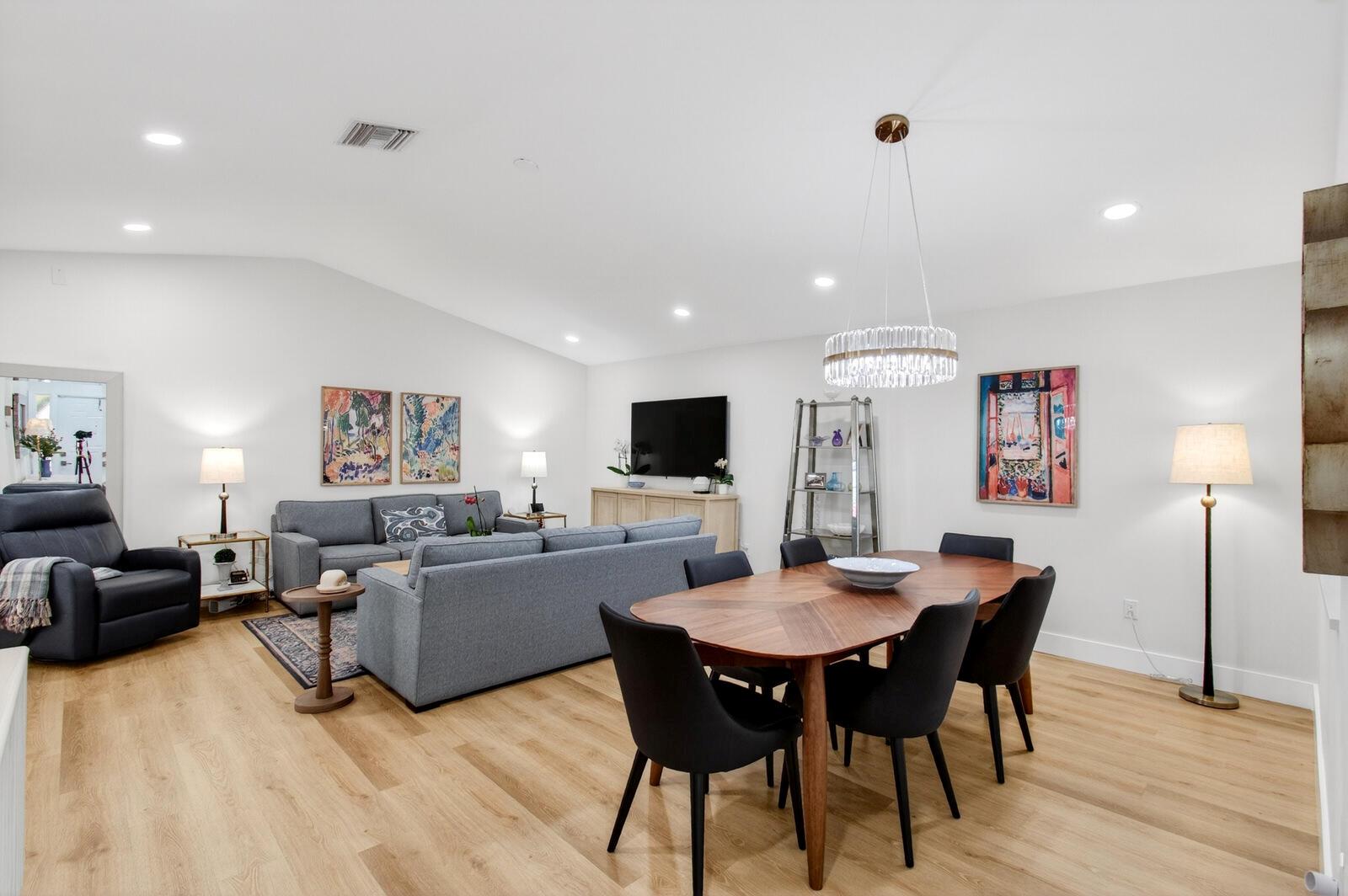 A living and dining room with light wood floors, gray furniture, and a crystal chandelier — 23377 Barlake Drive, Boca Raton FL 33433, BOCA RATON, FL