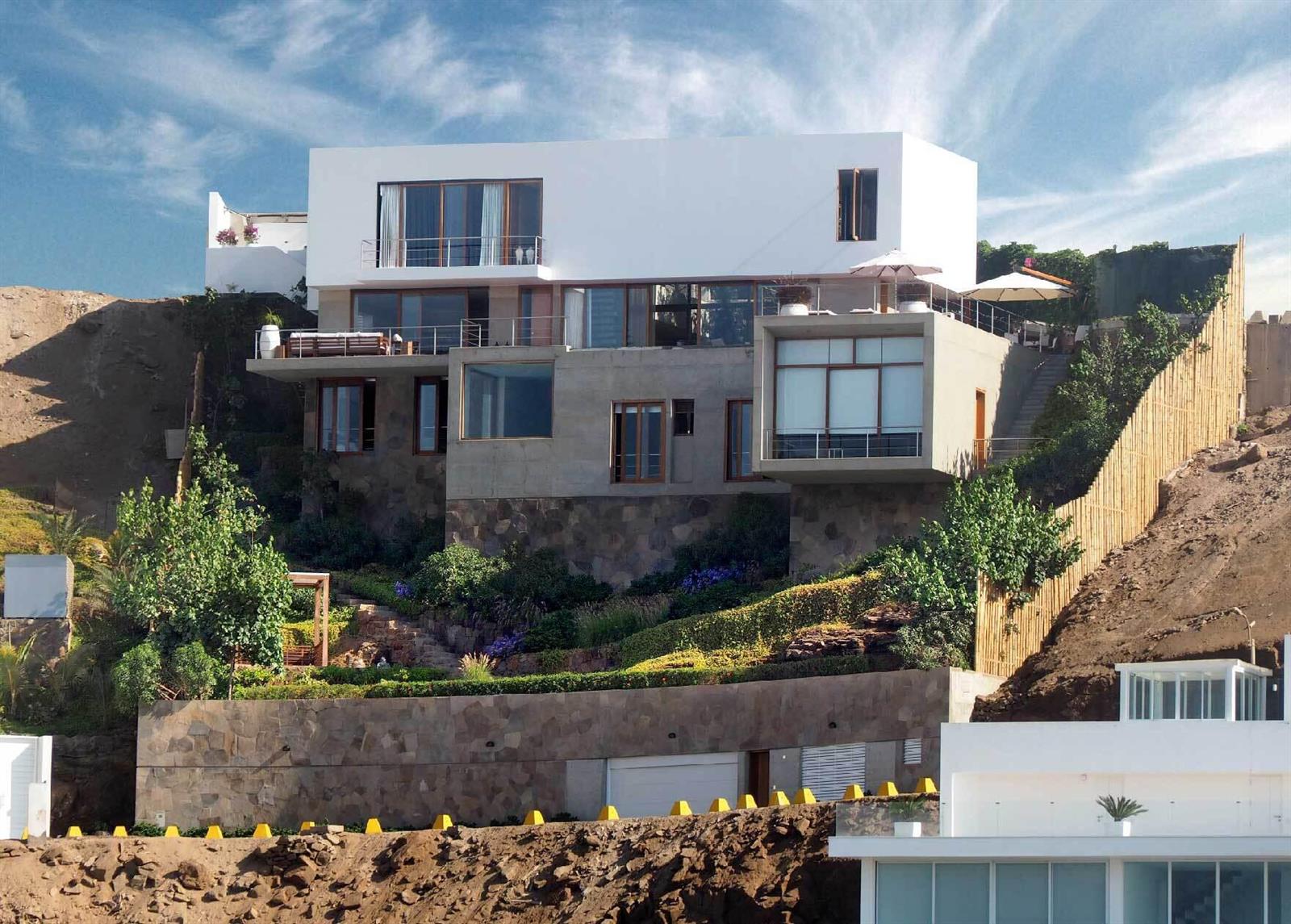 A modern multi-level house with concrete and stone exterior walls built into a steep hillside — 0600 Zona Sol Del Mar Mz.J Lt.5-6 # 0026, FL