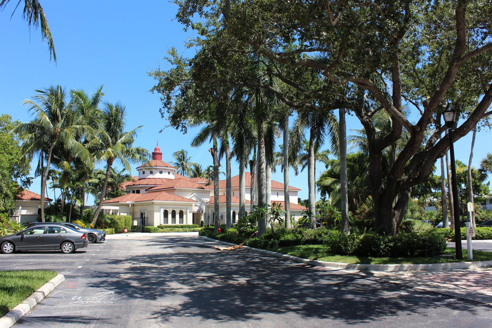 A multi-story building with a red tile roof stands behind a parking lot and trees — 3302 Tuscany Way, Boynton Beach FL 33435, BOYNTON BEACH, FL