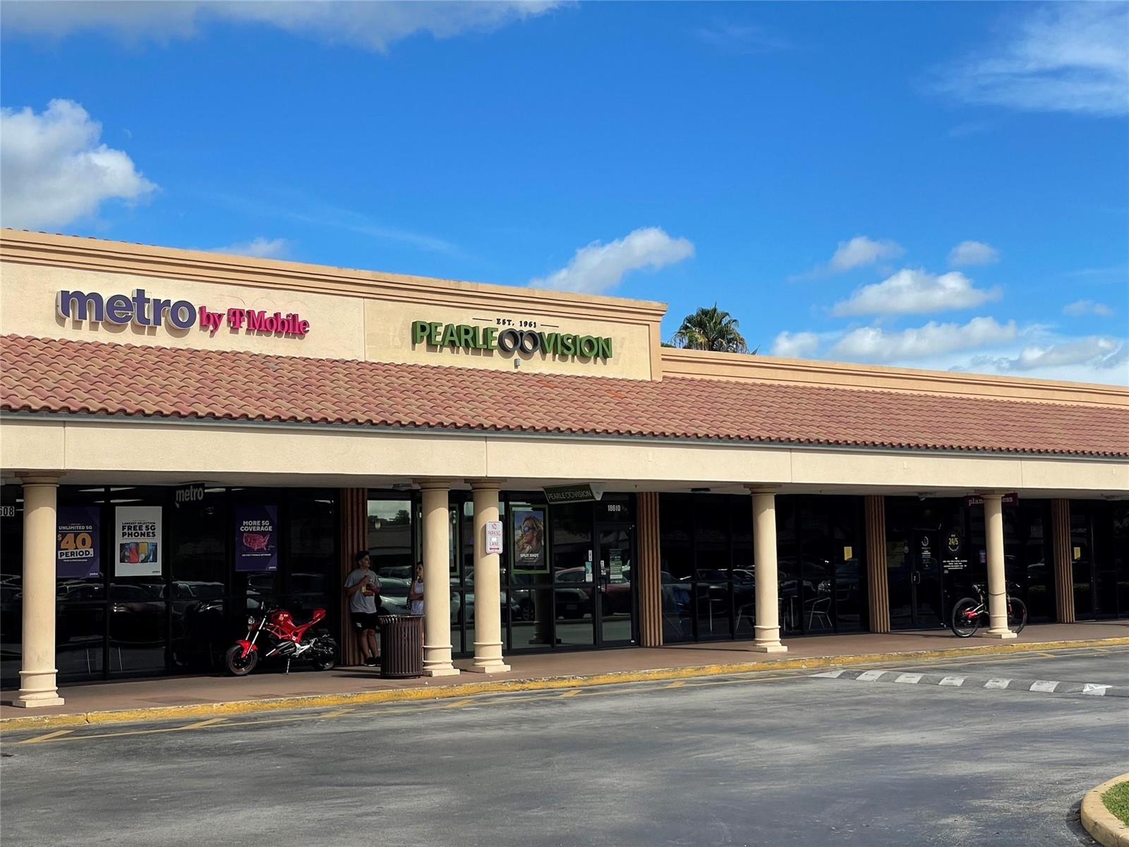 A strip mall exterior features a Metro by T-Mobile and a Pearle Vision store — 18606 NW 67th Avenue, Hialeah FL 33015, HIALEAH, FL