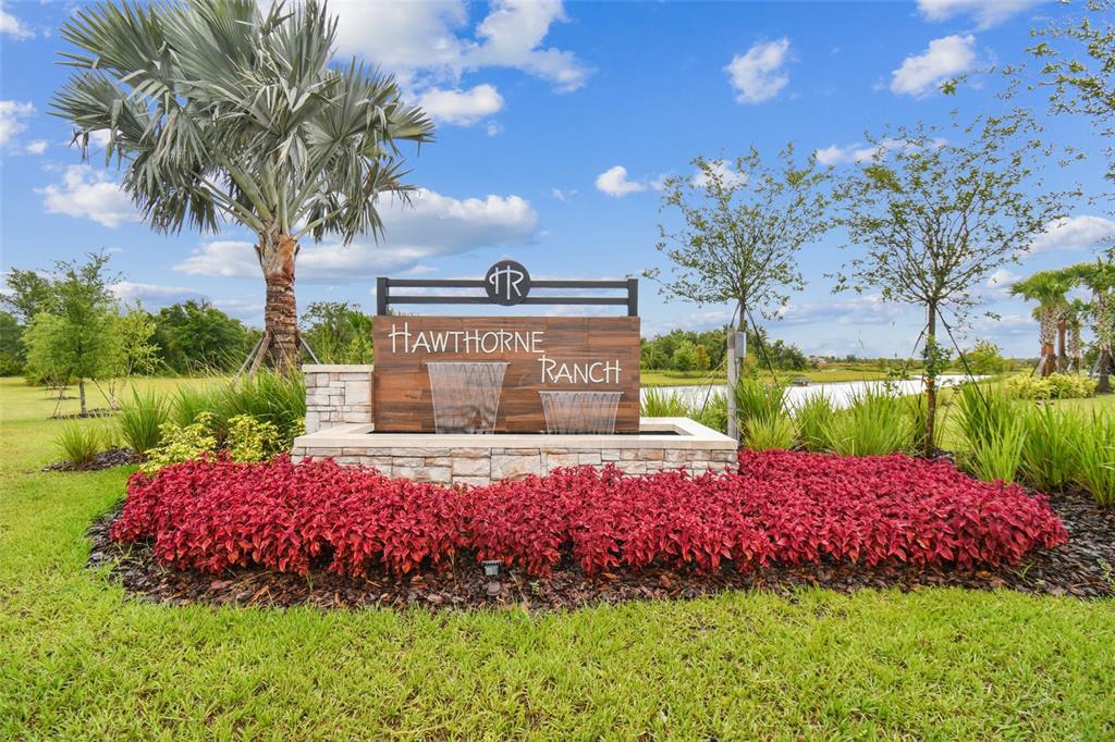A stone and wood monument sign for Hawthorne Ranch sits in a landscaped garden bed — 5603 FREESIA DRIVE, LAKELAND, FL