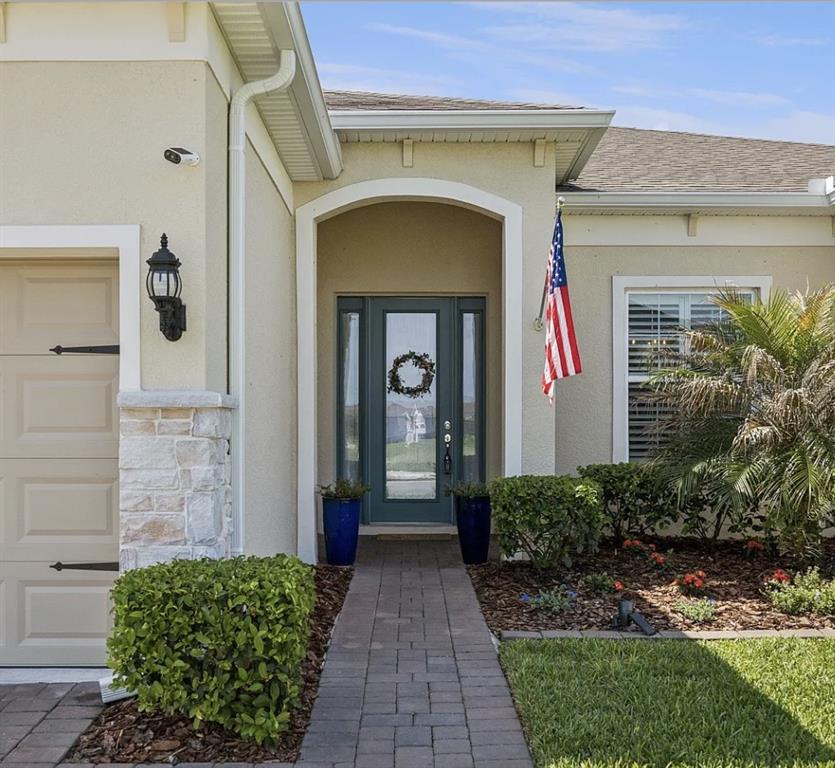 The exterior of a house features a paved walkway leading to a blue front door — 16118 BOWLINE STREET, ORLANDO, FL