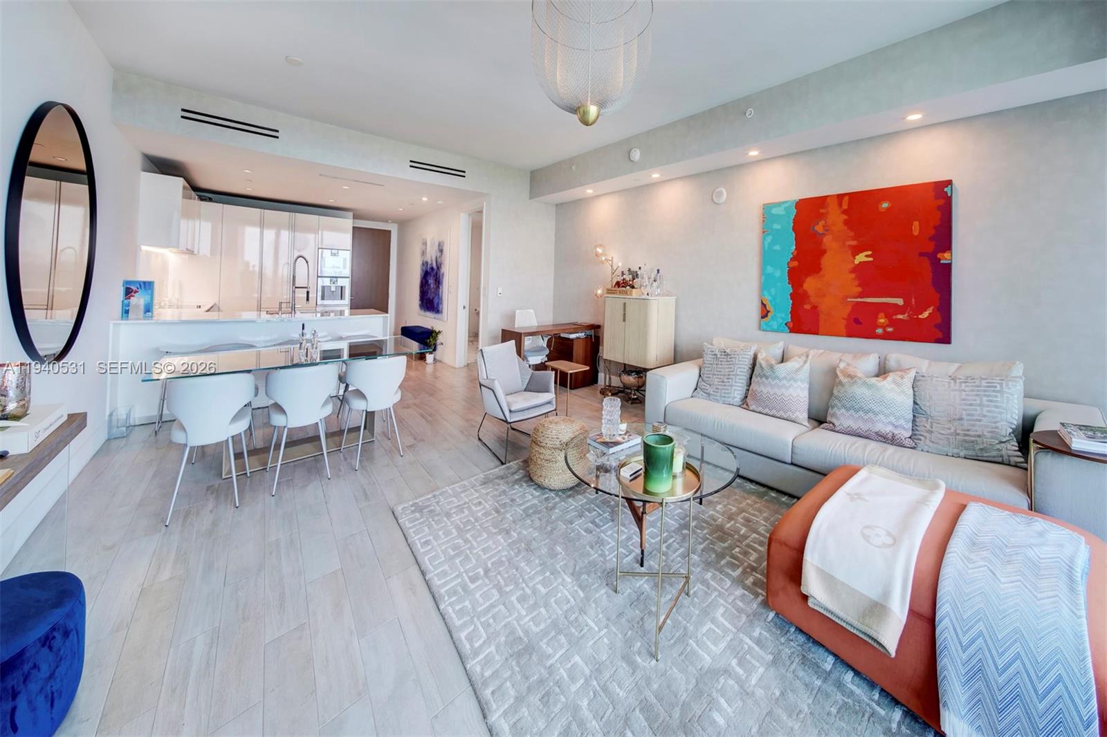 A modern living room features a sofa, dining area, and open kitchen with light flooring — 10201 Collins Ave # 804, Bal Harbour FL 33154, BAL HARBOUR, FL