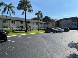 A multi-story apartment building with palm trees and a parking lot in front — 4000 Crystal Lake Dr # 111, Deerfield Beach FL 33064, DEERFIELD BEACH, FL