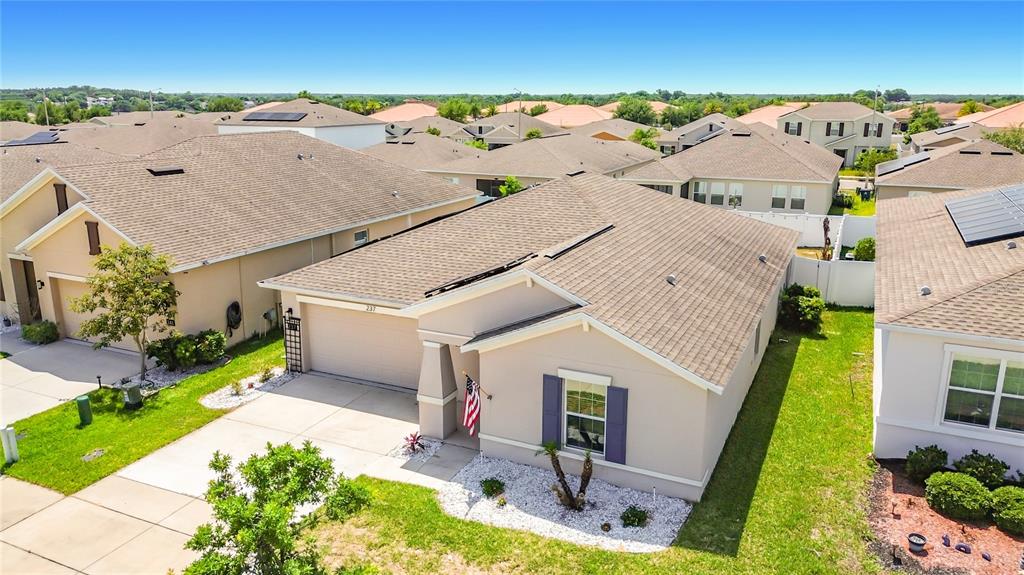 An aerial view shows a single-story suburban house with a tan exterior and shingled roof — 237 TAFT DRIVE, DAVENPORT, FL