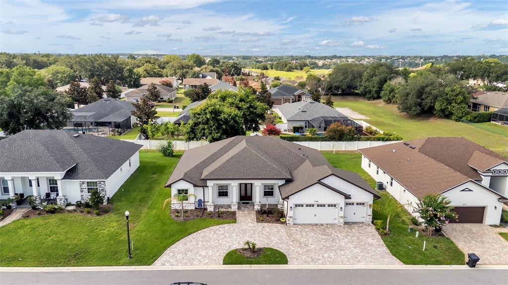 An aerial view shows a single-story suburban house with a paved driveway and dark roof — 2729 SUNRISE LANDING LANE, LAKELAND, FL