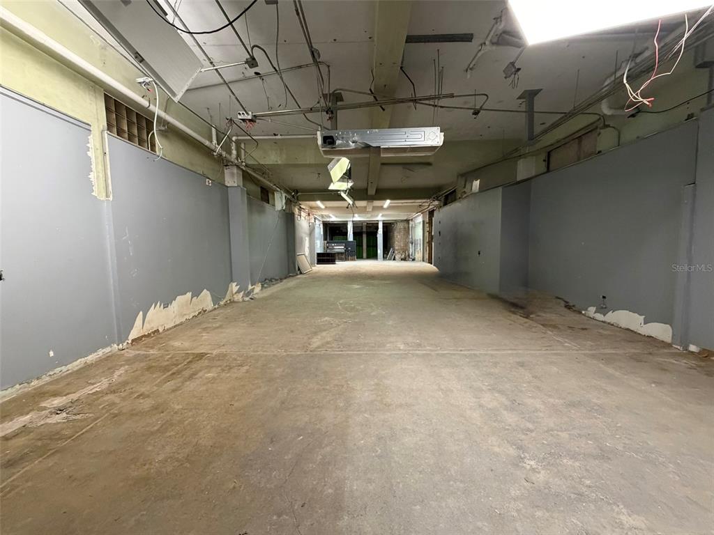 An unfinished, narrow commercial space features exposed ceiling utilities, gray walls, and concrete flooring — 1204 PONCE DE LEON AVENUE UNIT LOCAL B, SAN JUAN, PR