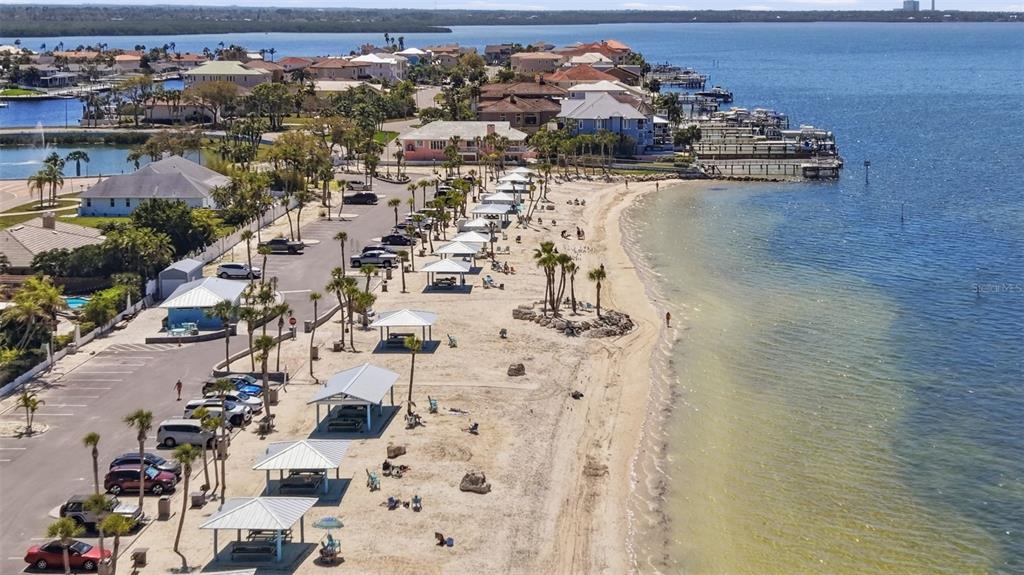 An aerial view shows a sandy beach with picnic shelters, palm trees, and a parking lot — 4301 MARINE PARKWAY, NEW PORT RICHEY, FL