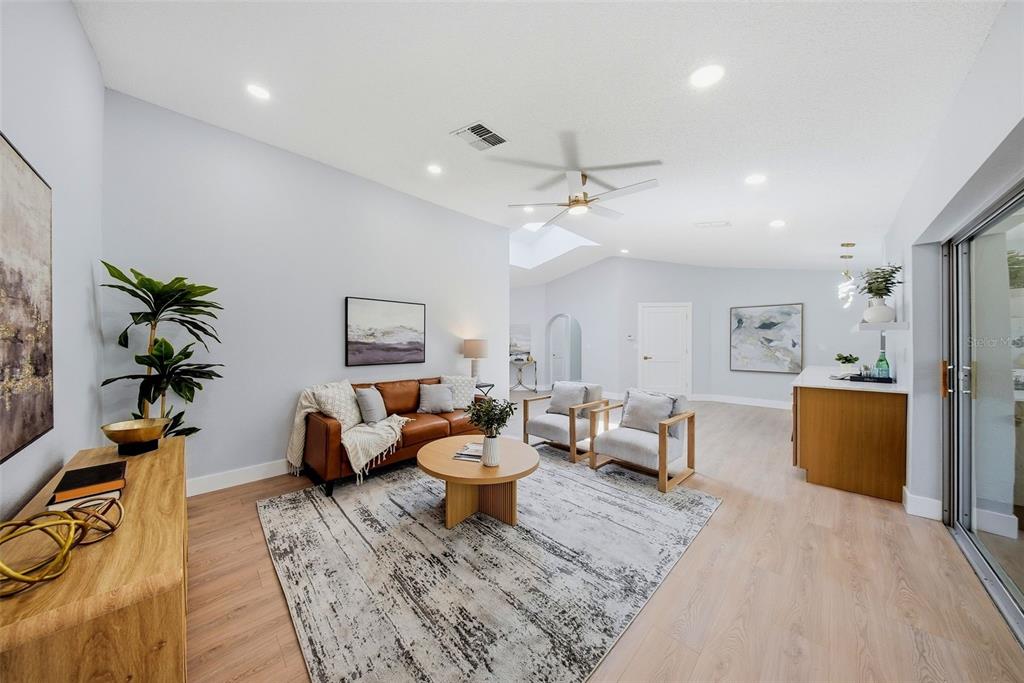 A living room features a leather sofa, two armchairs, a round coffee table, and light flooring — 4301 MARINE PARKWAY, NEW PORT RICHEY, FL