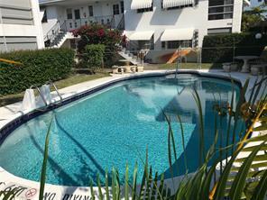 An outdoor swimming pool sits in front of a multi-story apartment building with white balconies — 3720 Harrison Street # 3, Hollywood FL 33021, HOLLYWOOD, FL