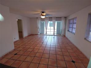 A spacious room with terracotta tile flooring, a ceiling fan, and sliding glass doors — 3720 Harrison Street # 3, Hollywood FL 33021, HOLLYWOOD, FL