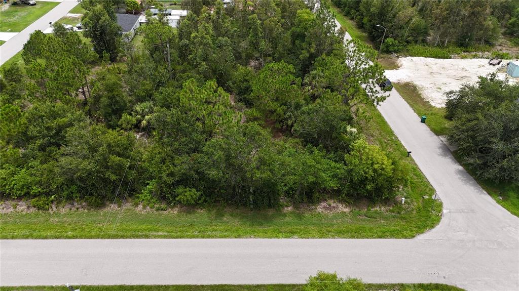 An aerial view shows a wooded, undeveloped residential lot situated at a street corner — 11317 4TH AVENUE, PUNTA GORDA, FL