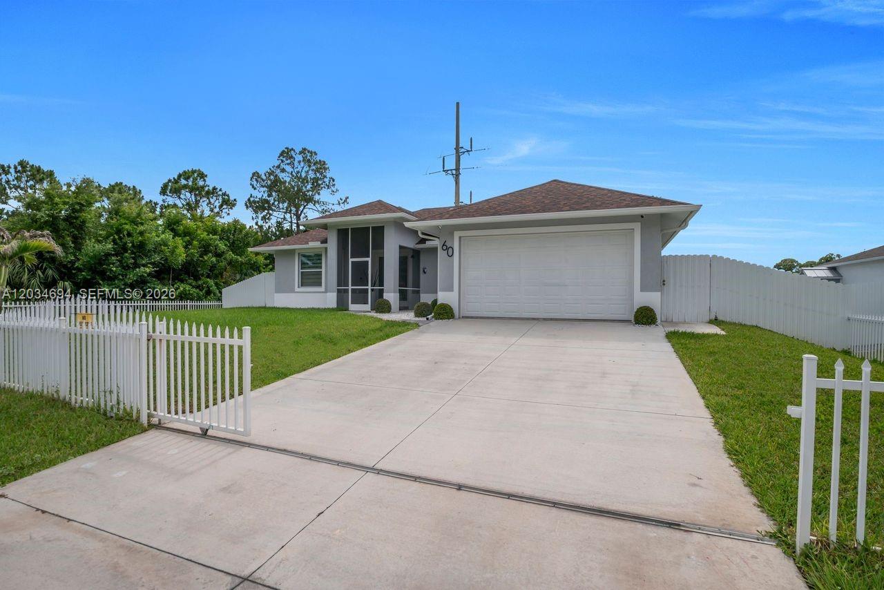 A single-story house with a white garage, gray exterior, and a white picket fence — 60 Floyd Ave S, Lehigh Acres FL 33976, LEHIGH ACRES, FL