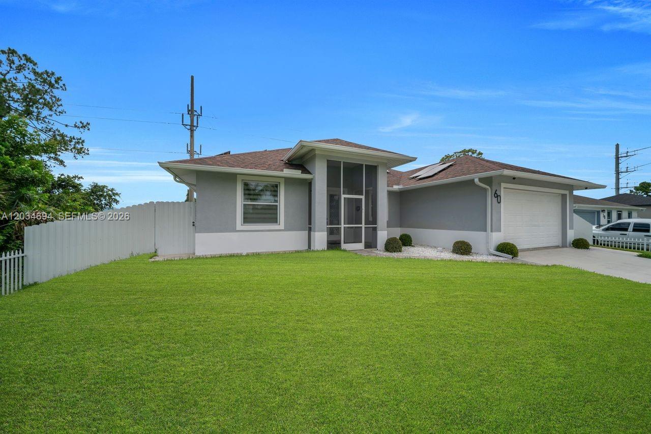 A single-story gray house with a white garage and a large front lawn — 60 Floyd Ave S, Lehigh Acres FL 33976, LEHIGH ACRES, FL