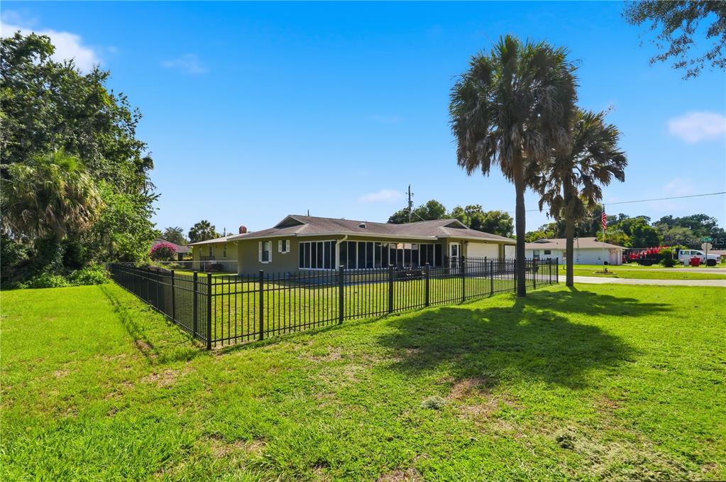 A single-story house with a screened-in back porch and a black metal fence — 1381 CR 446A, LAKE PANASOFFKEE, FL