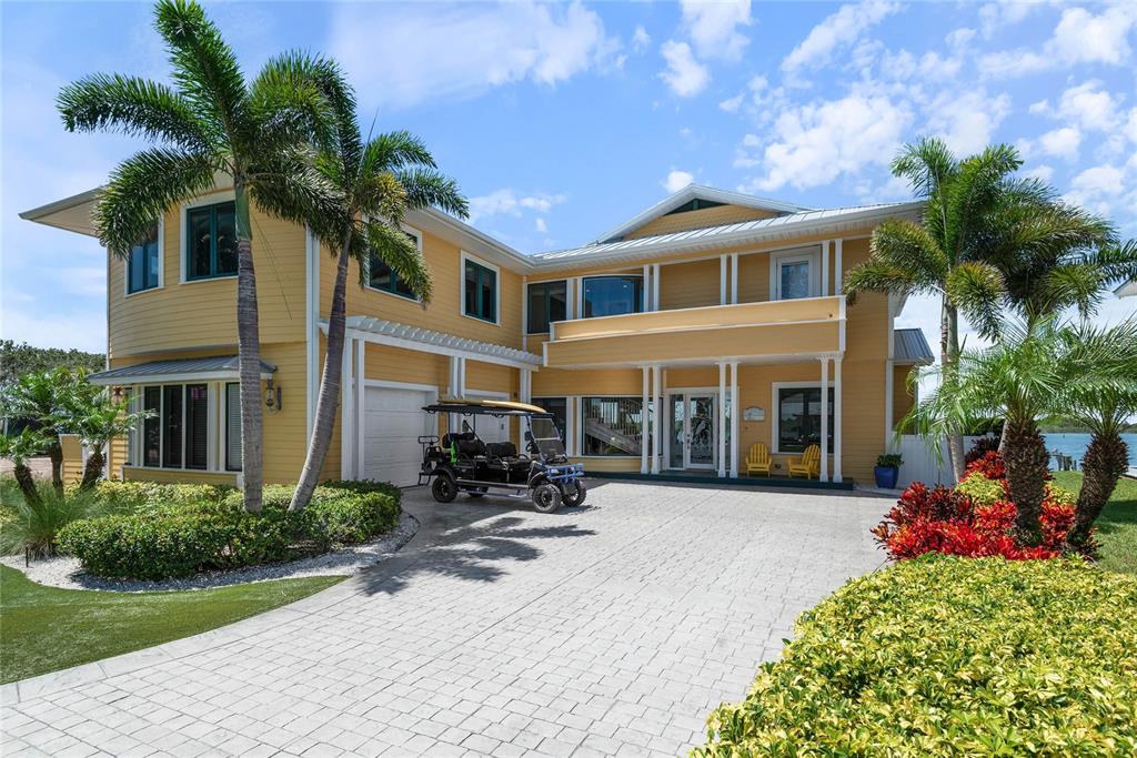 An aerial view shows waterfront houses with metal roofs along a curved residential street — 2012 SPYGLASS LANE, NEW SMYRNA BEACH, FL