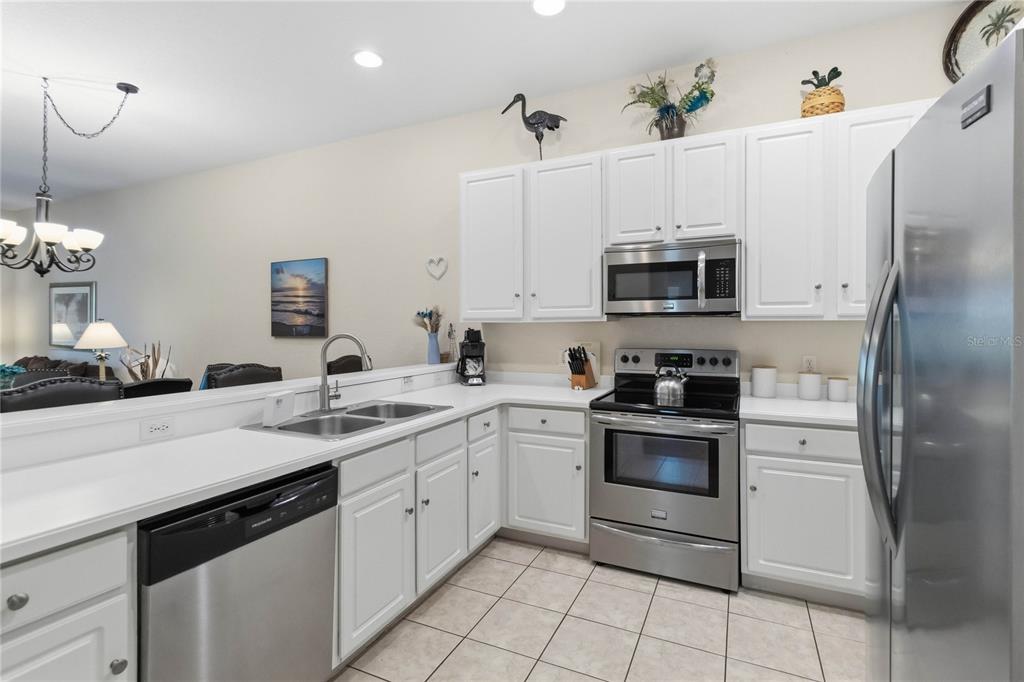 A kitchen features white cabinets, stainless steel appliances, and a tiled floor — 307 NEW PROVIDENCE PROMENADE UNIT 0, DAVENPORT, FL