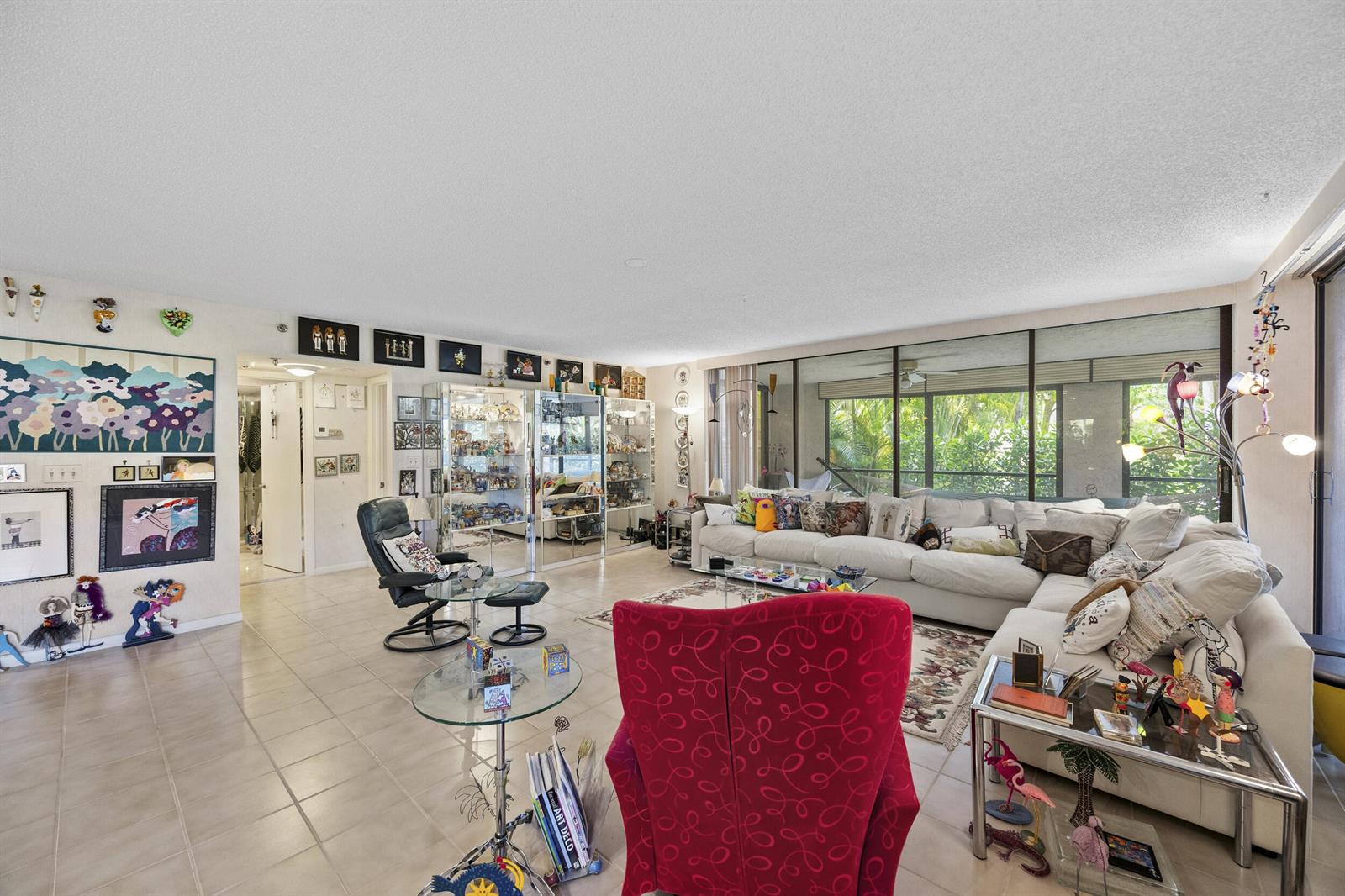 A living room with tile floors, a large sectional sofa, and a red armchair — 7209 Promenade Drive # 101, Boca Raton FL 33433, BOCA RATON, FL