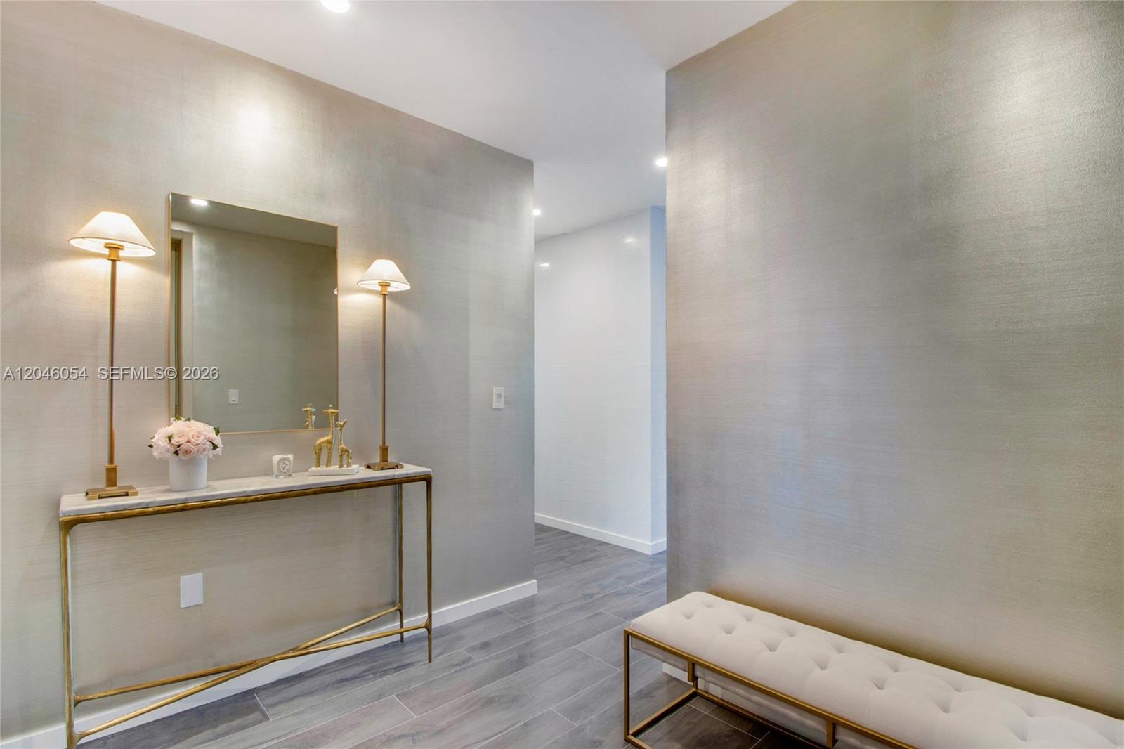 A hallway features metallic wallpaper, a marble-topped console table, a tufted bench, and two lamps — 1000 Brickell Plz, Miami FL 33131, MIAMI, FL