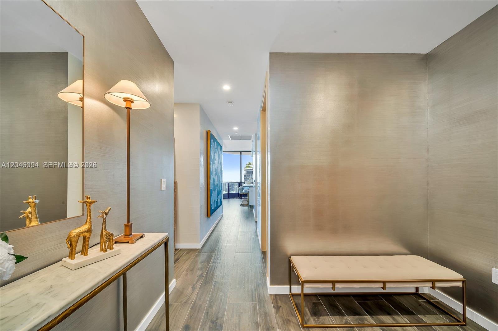 A hallway features metallic wallpaper, a marble console table with giraffe figurines, and a bench — 1000 Brickell Plz, Miami FL 33131, MIAMI, FL