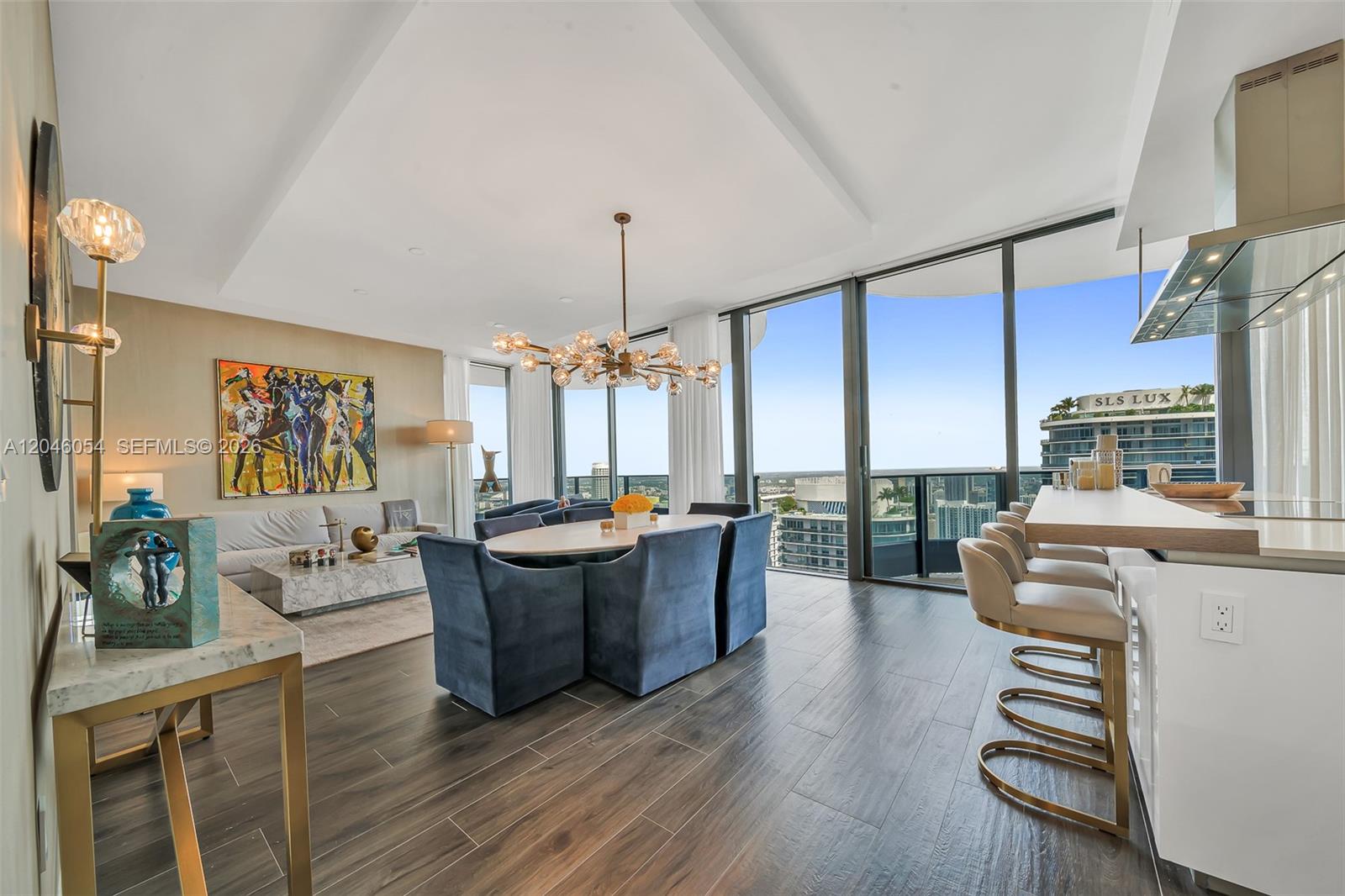 A modern open-concept living and dining area features floor-to-ceiling windows and a kitchen island — 1000 Brickell Plz, Miami FL 33131, MIAMI, FL