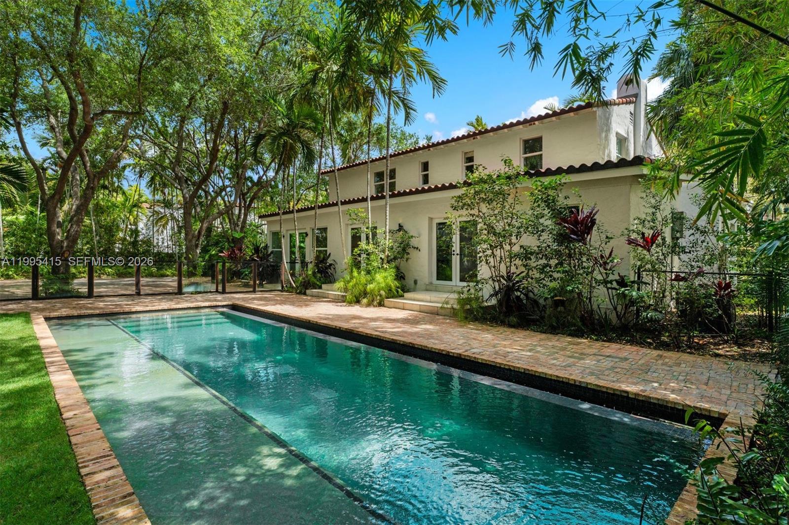 A two-story white house with a tile roof overlooks a rectangular swimming pool — 5812 Alton Rd, Miami Beach FL 33140, MIAMI BEACH, FL