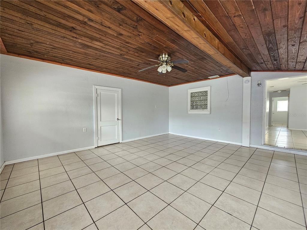 A room with light gray walls, white tile flooring, and a wood-paneled ceiling with a fan — 1212 W MARJORIE STREET, LAKELAND, FL