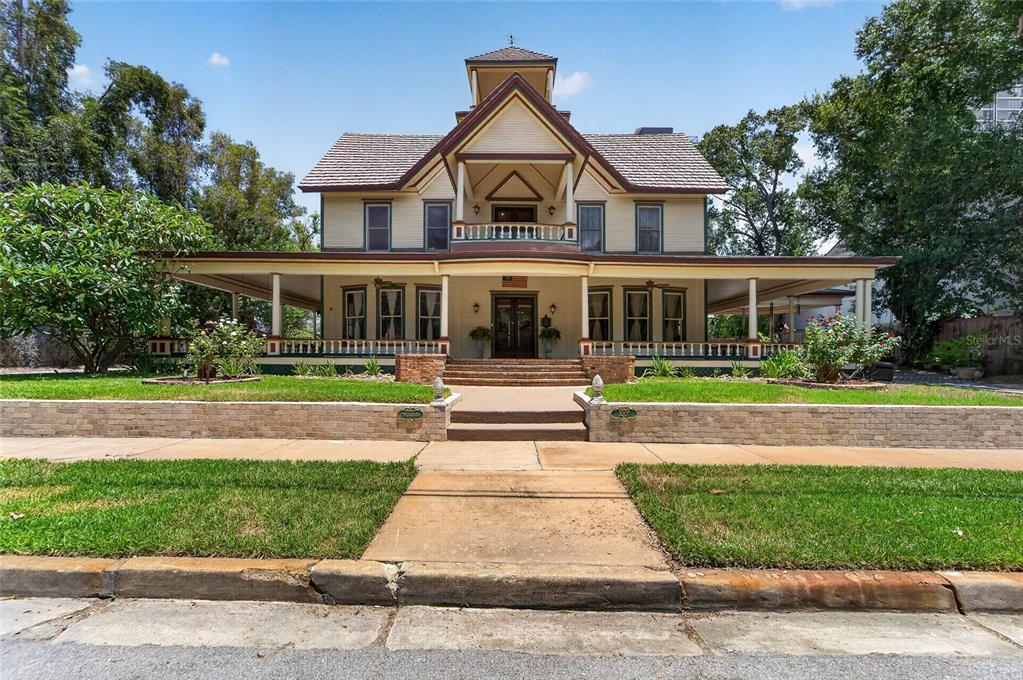 A two-story Victorian-style house features a large wrap-around porch and a central balcony — 3007 W STOVALL STREET, TAMPA, FL