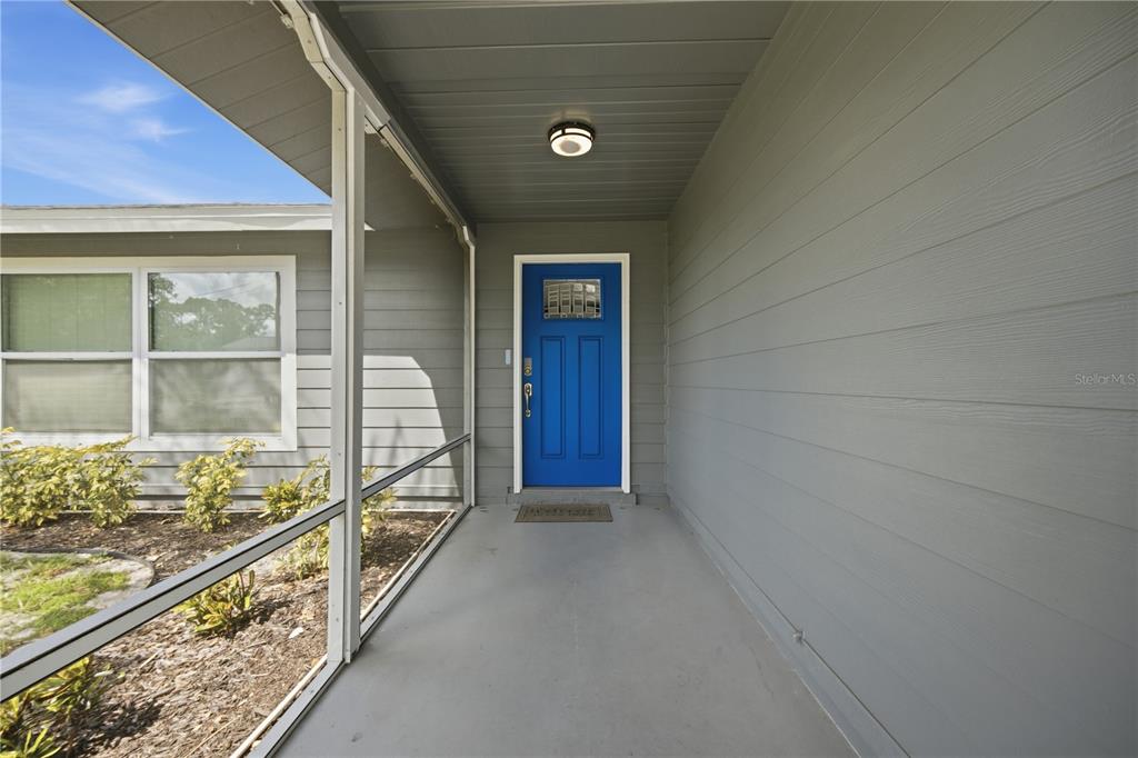 A covered porch leads to a bright blue front door with a small window — 1964 PAR PLACE, SARASOTA, FL