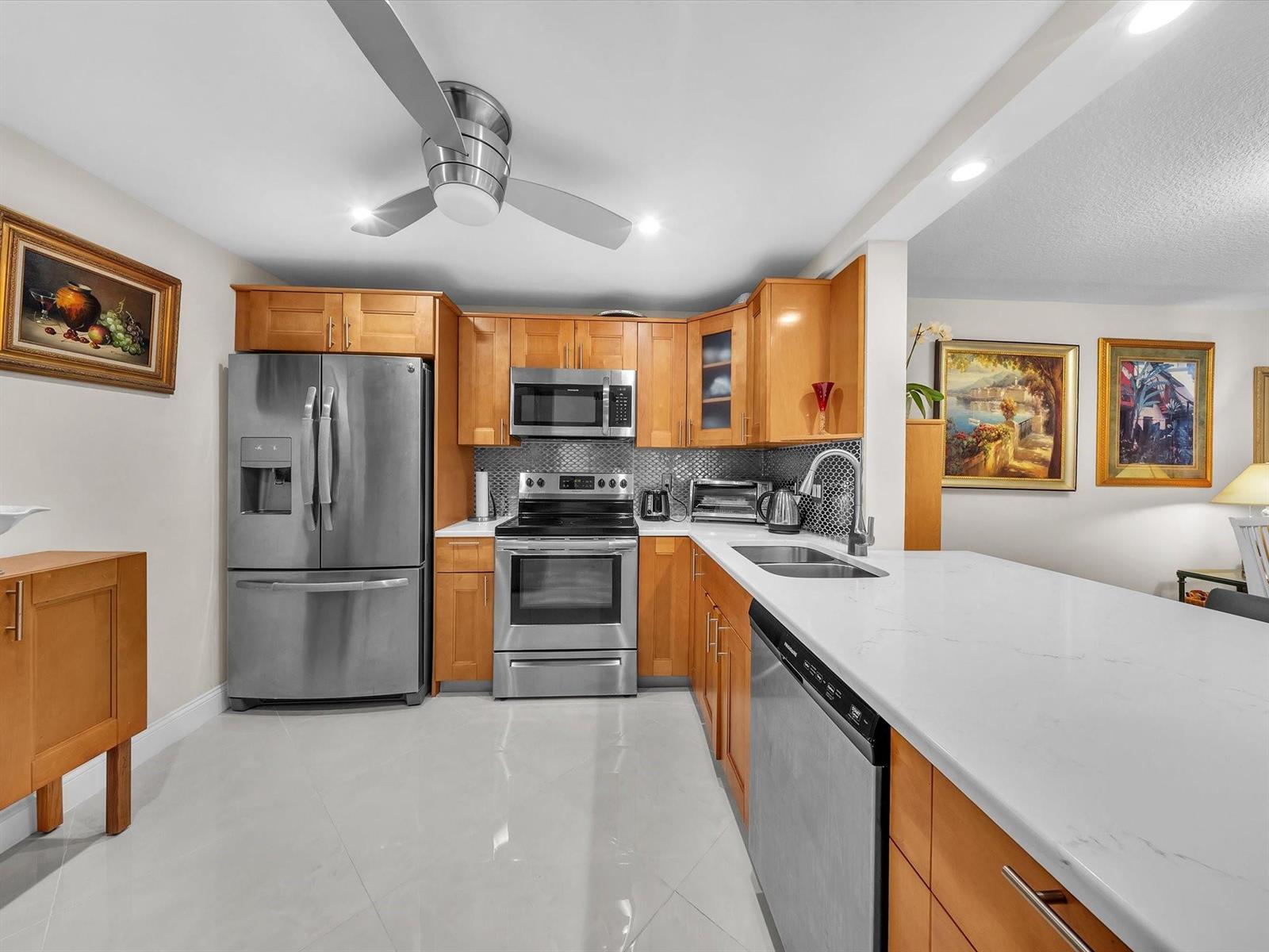 A kitchen features stainless steel appliances, light wood cabinets, and white countertops — 2515 NE 1st Court # 314, Boynton Beach FL 33435, BOYNTON BEACH, FL
