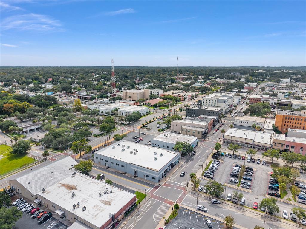 An aerial view shows a city street intersection surrounded by commercial buildings and parking lots — 125 N 1ST AVENUE, OCALA, FL