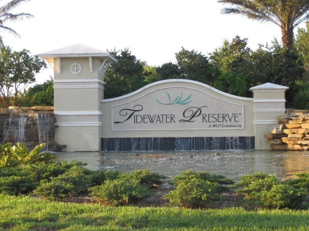 The entrance sign for Tidewater Preserve features a stone wall with a cascading water feature — 850 TIDEWATER SHORES LOOP UNIT 402, BRADENTON, FL