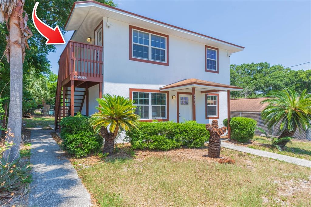 A two-story white house with brown trim, a wooden balcony, and a small front porch — 8510 N TAMPA STREET UNIT B, TAMPA, FL